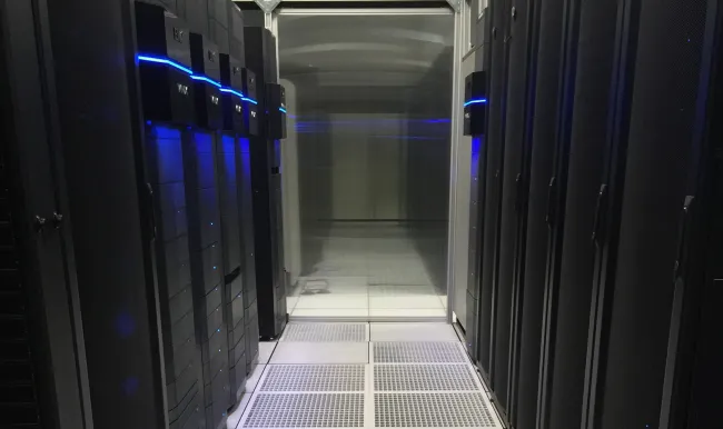 A hallway with several black servers

Description automatically generated with medium confidence