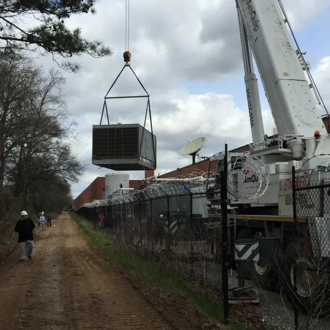 A crane lifting a large container

Description automatically generated