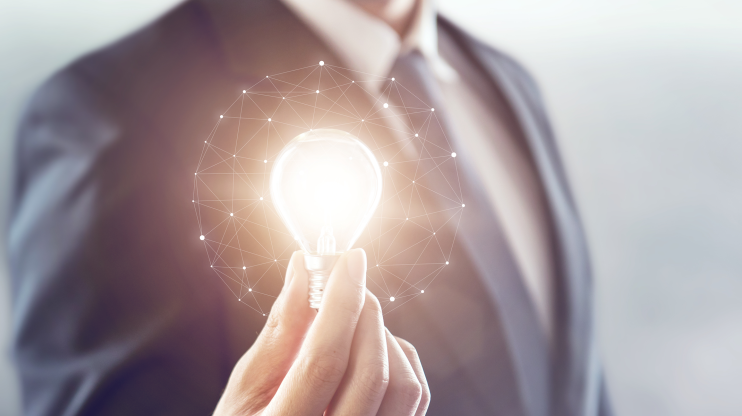 man in suit holding light bulb